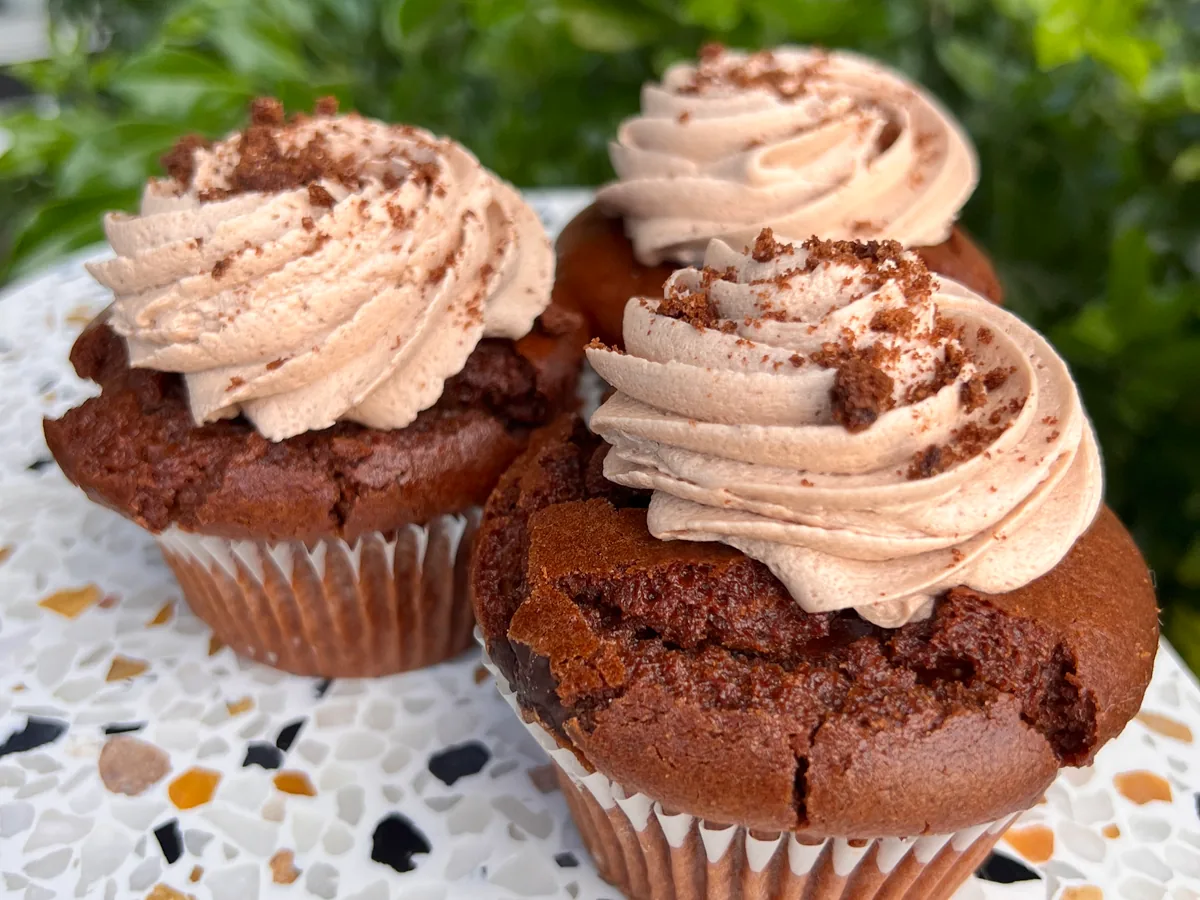 Two chocolate cupcakes with piped frosting.