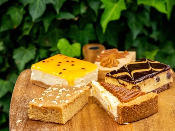 Passionfruit, caramel and chocolate slices on a wooden board.